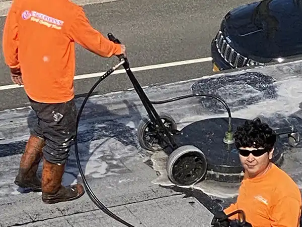 Workers washing and preparing a commercial roof for service